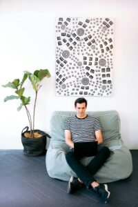 Young man working on laptop in stylish home office setting with modern decor.