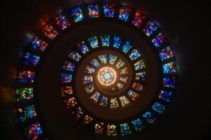 Captivating spiral stained glass art with vibrant colors forming a dramatic eye-catching pattern.